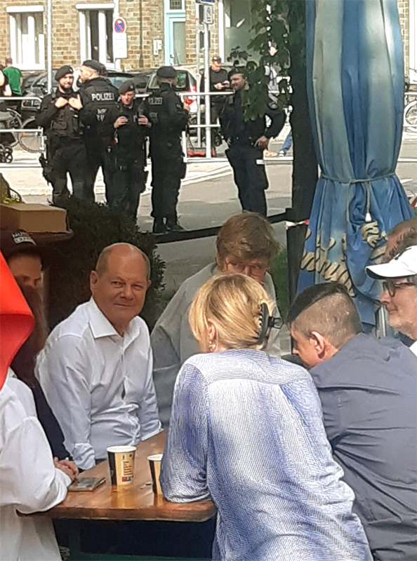Bundeskanzler Olaf Scholz (SPD) im Gespräch mit Organisatoren des „Düsseldorfer Büdchentages“ direkt vor Ort.